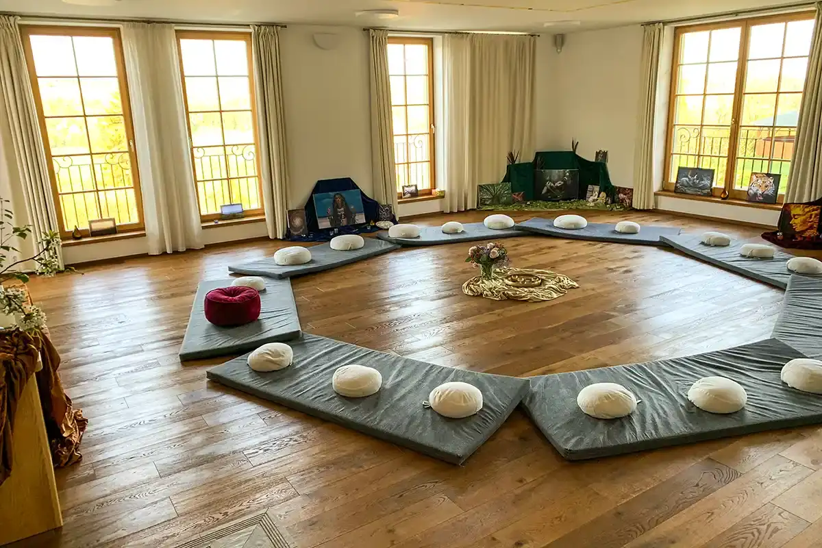 Ein heller Seminarraum mit Sitzkissen im Kreis.